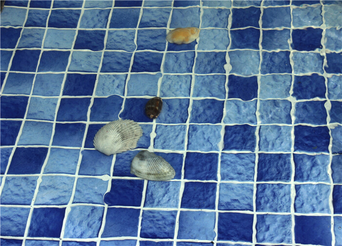 replacing light blue swimming pool step tile that is waving on surface.jpg
