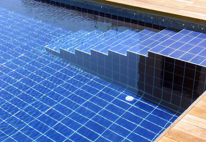 rectangular pool tiles placed vertically on pool bottom while horizontally on pool step.jpg