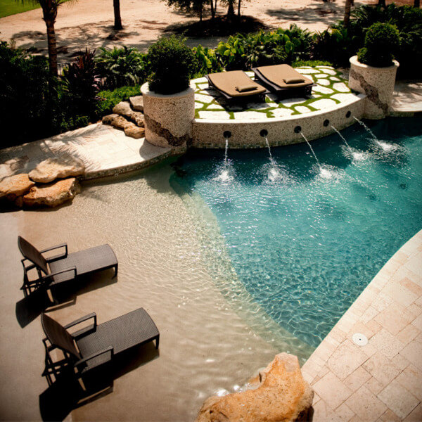 a beach entry pool with beach bench